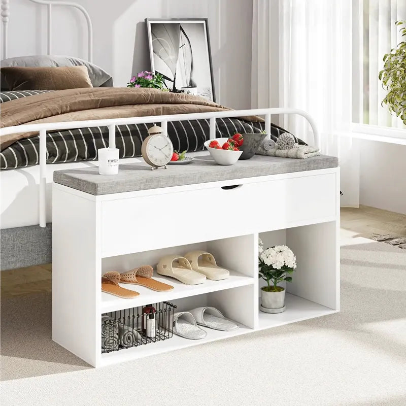 Banc à chaussures blanc avec coussin, design compact et rangement astucieux, idéal pour l'entrée ou le couloir.