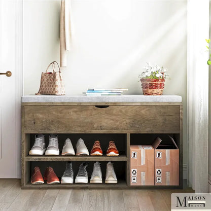 Banc à chaussures avec coussin de Maison Banc, design compact et espace de rangement intégré pour chaussures.