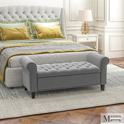 Banc coffre classique en velours gris capitonné, style suite Bellina, avec repose-pieds et détails élégants.
